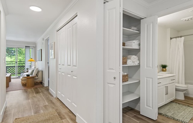 a white bathroom with white closets and a white toilet