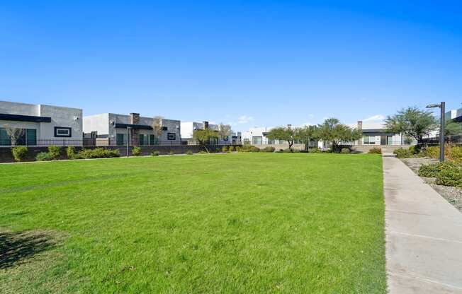 a green lawn in front of a row of apartment buildings