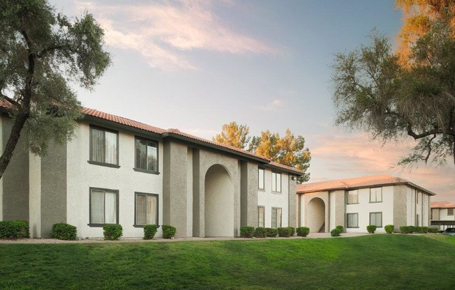 a building with a lawn and trees in front of it