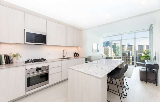 a kitchen with white cabinets and a marble counter top
