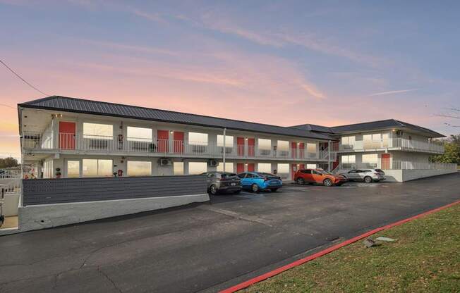 A parking lot with cars and a building in the background.