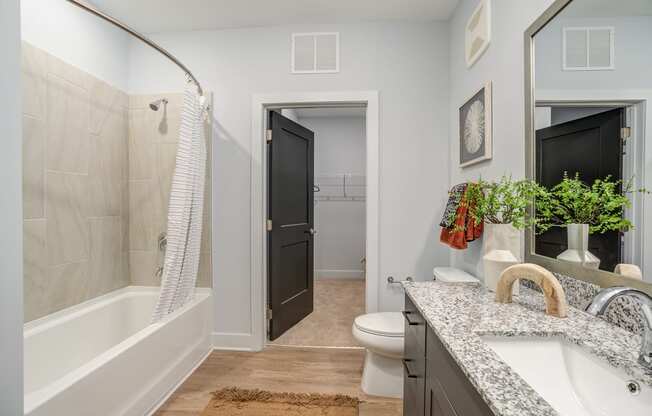 a bathroom with gray walls and a white bathtub