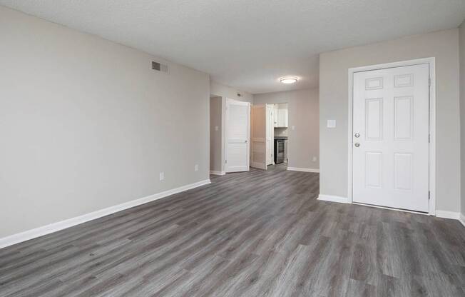 A room with a white door and a grey floor.