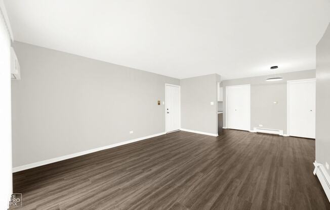 an empty living room with white walls and wood floors