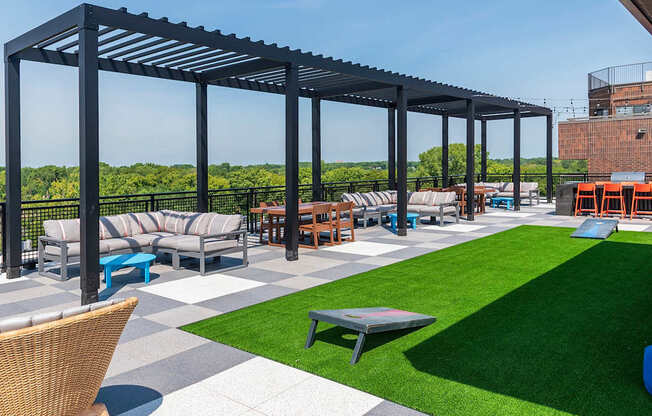 A patio with a black metal pergola and a variety of seating options.