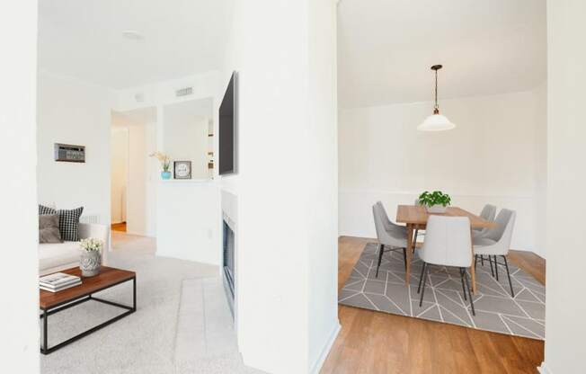 a living room and dining room with a table and chairs