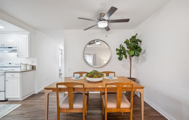 a dining room with a table and chairs and a ceiling fan