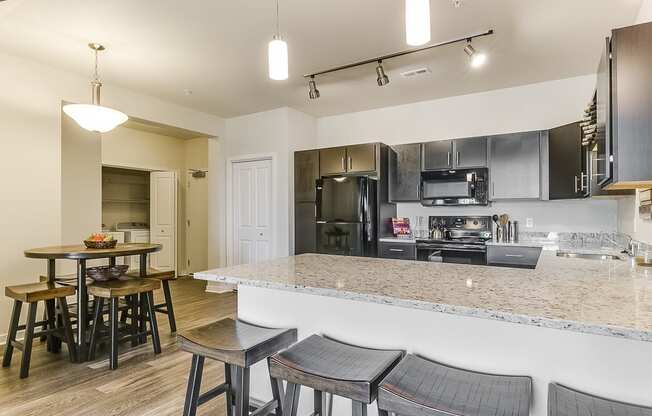 a kitchen with a large island with a breakfast bar and stools