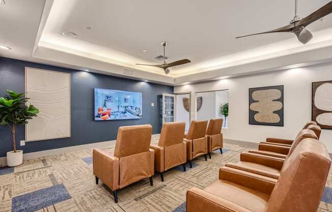 a conference room with leather chairs and a wall mounted tv