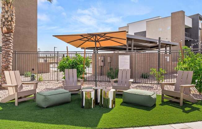 A patio area with a table, chairs, and a parasol.