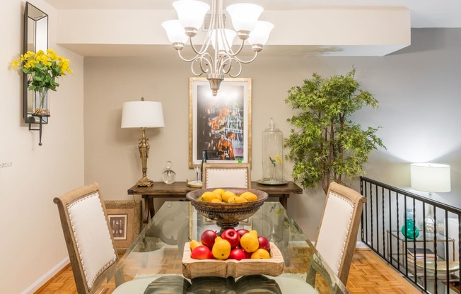 a dining room with a glass table with fruit on it