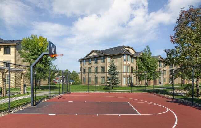 a basketball court in front of an apartment building