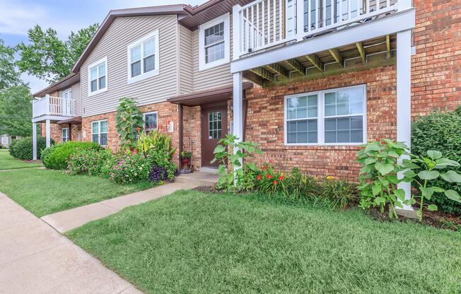 a house with a lawn in front of a brick building