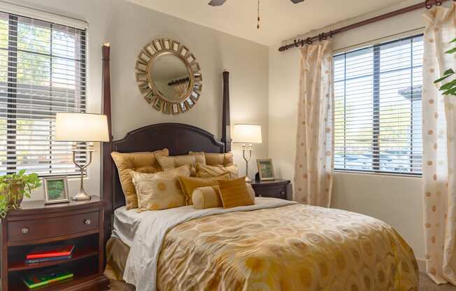 a bedroom with a large bed and two windows