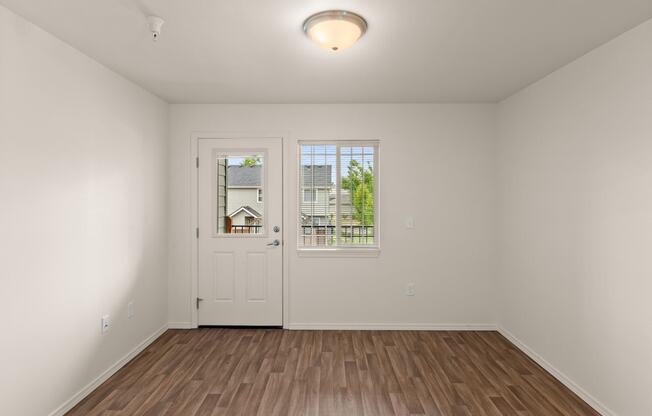 a living room with white walls and a door to a balcony