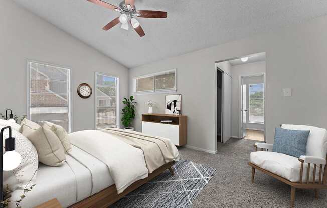 A bedroom with a bed, chair, and a ceiling fan.