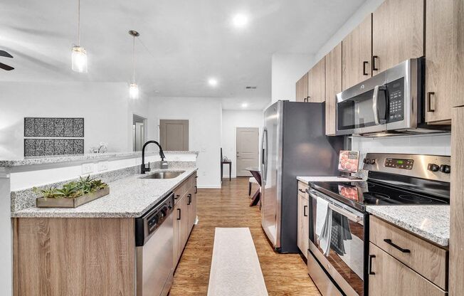 a kitchen with stainless steel appliances and marble counter tops