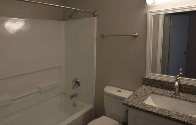 A bathroom with a toilet, sink, and bathtub.