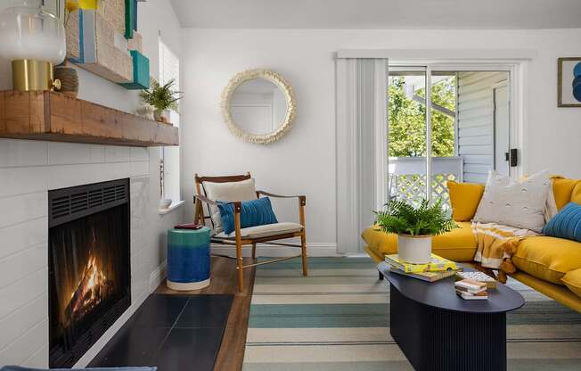 A living room with a fireplace and a yellow couch.