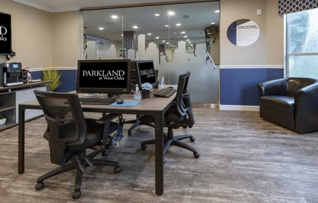 a desk with two computers and a chair in an office