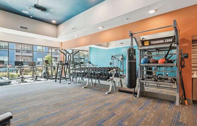 A gym with a variety of equipment including weights and a leg press machine.