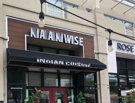 The front of a restaurant named Naanwise with an Indian Cuisine sign. at Calvert House Apartments, Washington, 20008