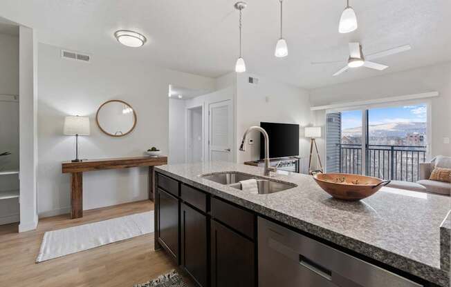 A modern kitchen with a large island and a view of the mountains.