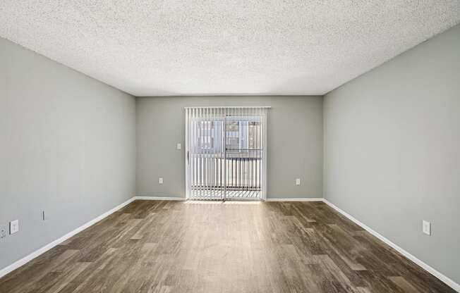 A room with a wooden floor and a white ceiling with a window.