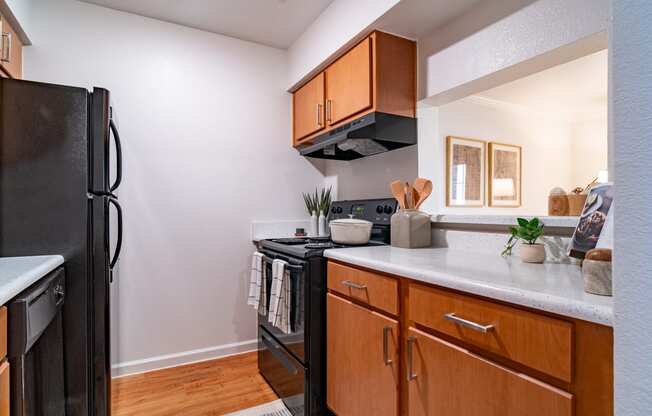 a kitchen with black appliances and wooden cabinets