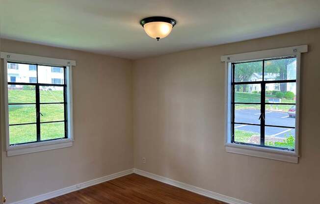 an empty room with two windows