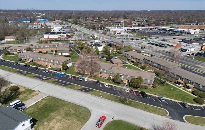 an aerial view of a city with cars parked in a parking lot