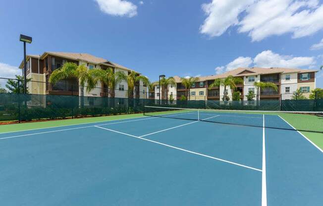 a tennis court in front of an apartment complex  at Cabana Club - Galleria Club, Jacksonville, FL, 32256