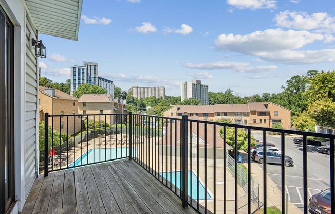 A balcony with a pool table and a view of the city.