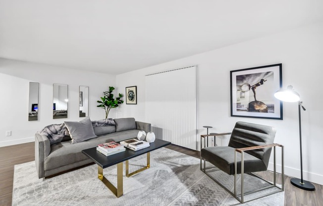 a living room with white walls and hardwood floors