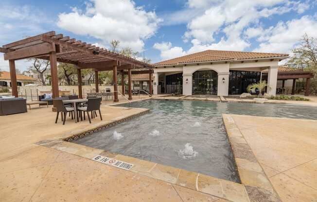 a pool with a patio and a building in the background