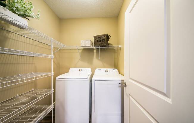 a laundry room with two washers and dryers next to a door