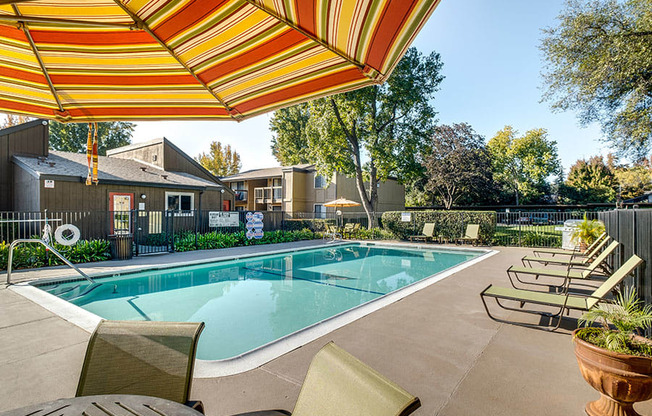 our apartments have a resort style pool with chairs and umbrellas