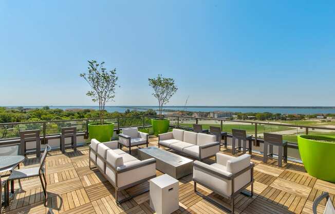 a large deck with couches and tables overlooking the ocean