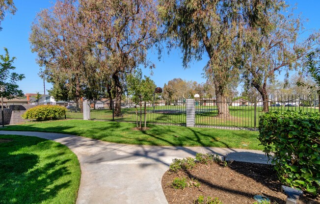 A park with a walking path and green grass.
