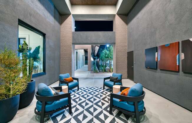 a lobby with blue chairs and a geometric rug