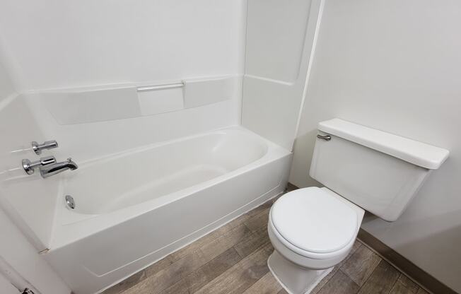 Clean and spacious bathroom with bathtub and toilet at Garfield Commons Apartments in Clinton Township, MI