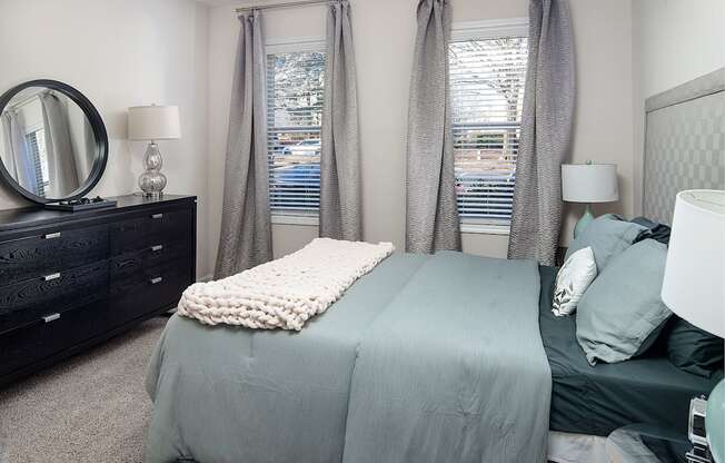 A bedroom with a bed, nightstand, and window.