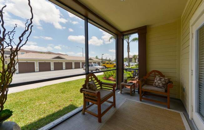 a porch with two chairs and a grassy area  at Cabana Club - Galleria Club, Florida