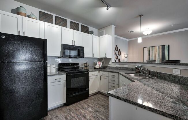 a kitchen with granite counter tops and black appliances