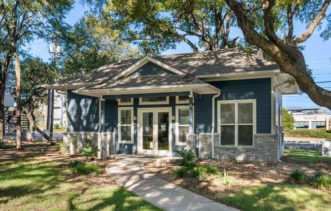 a small house with a sidewalk and trees in front of it at South Lamar Village, Austin, Texas