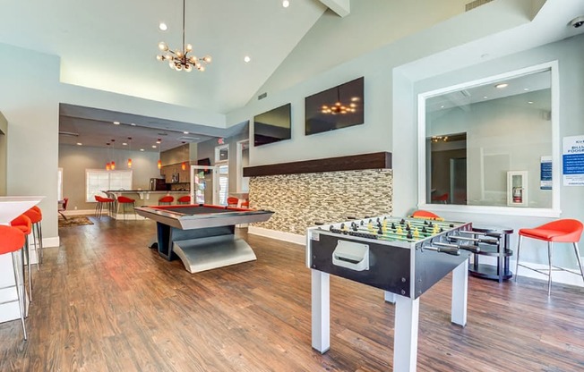A room with a foosball table and a shaggy rug.