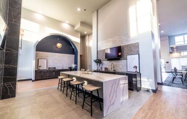 a large kitchen with a marble counter top and bar stools