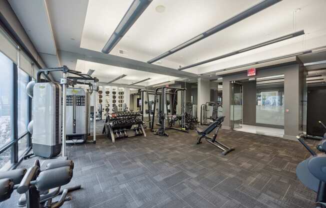 A gym with a variety of equipment including treadmills, weights, and exercise machines.