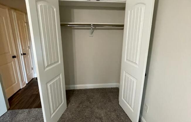 a bedroom with a closet and a closet door open