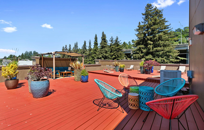 a roof deck with chairs and potted plants at Illumina Apartment Homes, Seattle, 98102